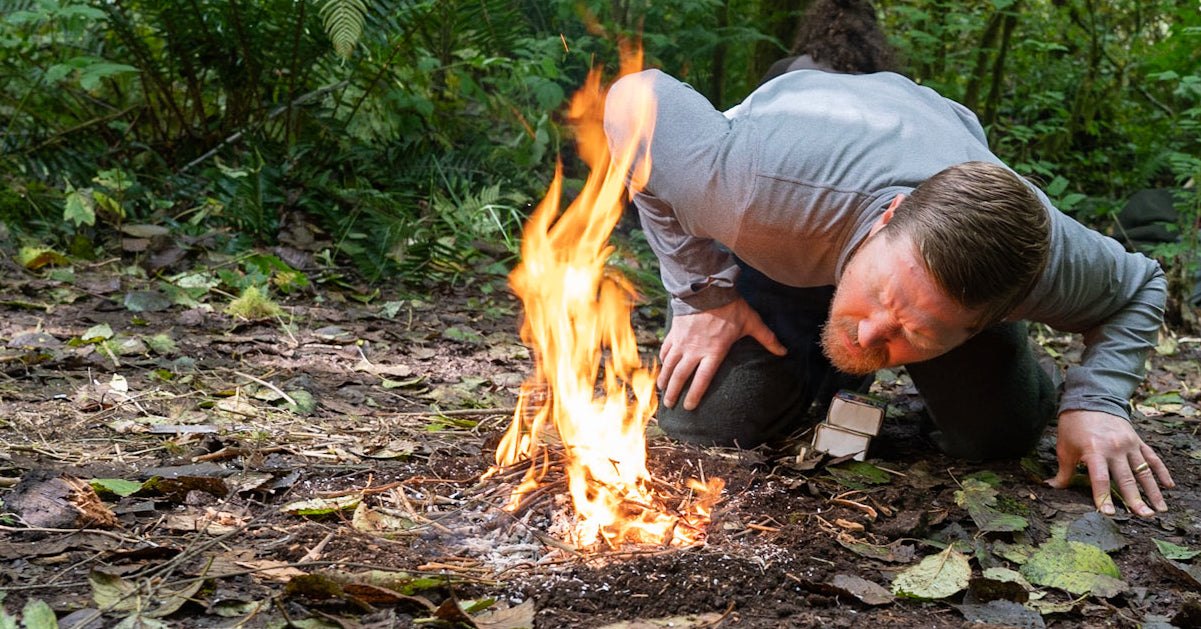 Person building a lean-to shelter in the wilderness demonstrating basic survival skills for emergencies