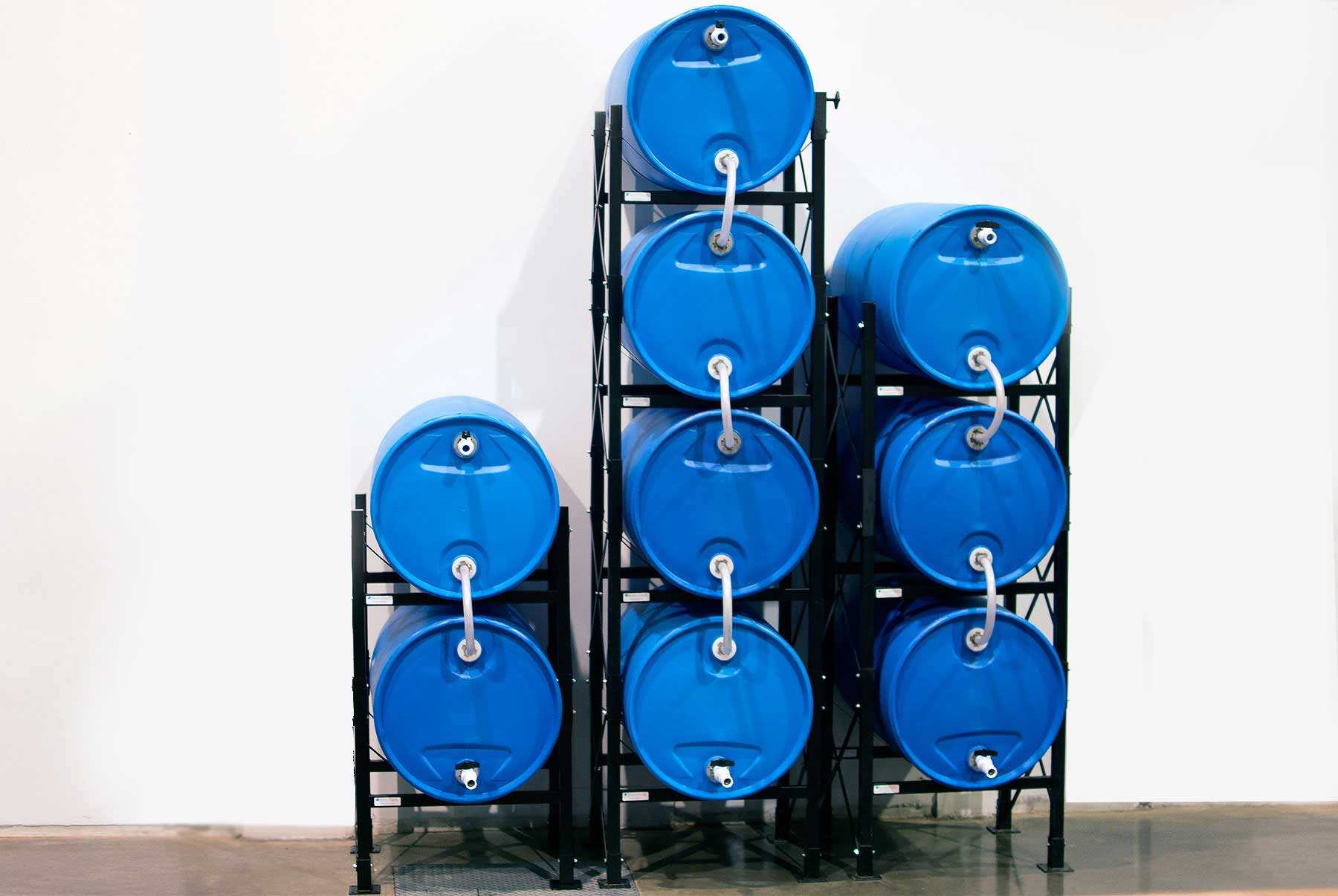 stacked blue water storage containers in a cool, dark organized shelving area for long-term water storage preparedness