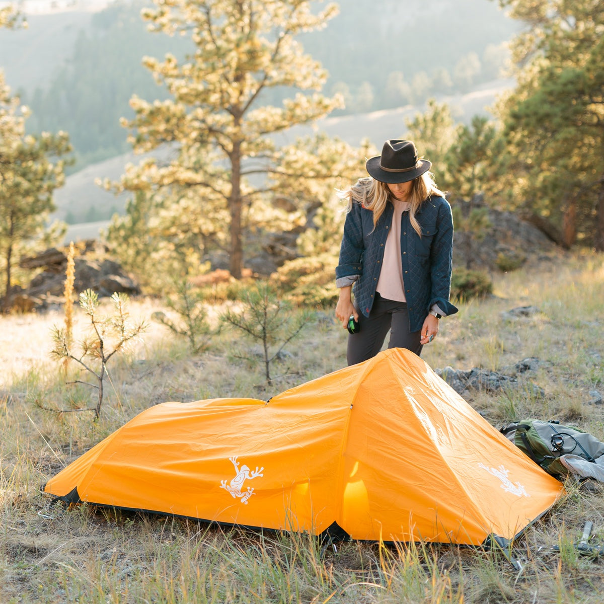 Orange Solo Bivy 1-Person Tent with waterproof rain fly and lightweight aluminum poles set up outdoors