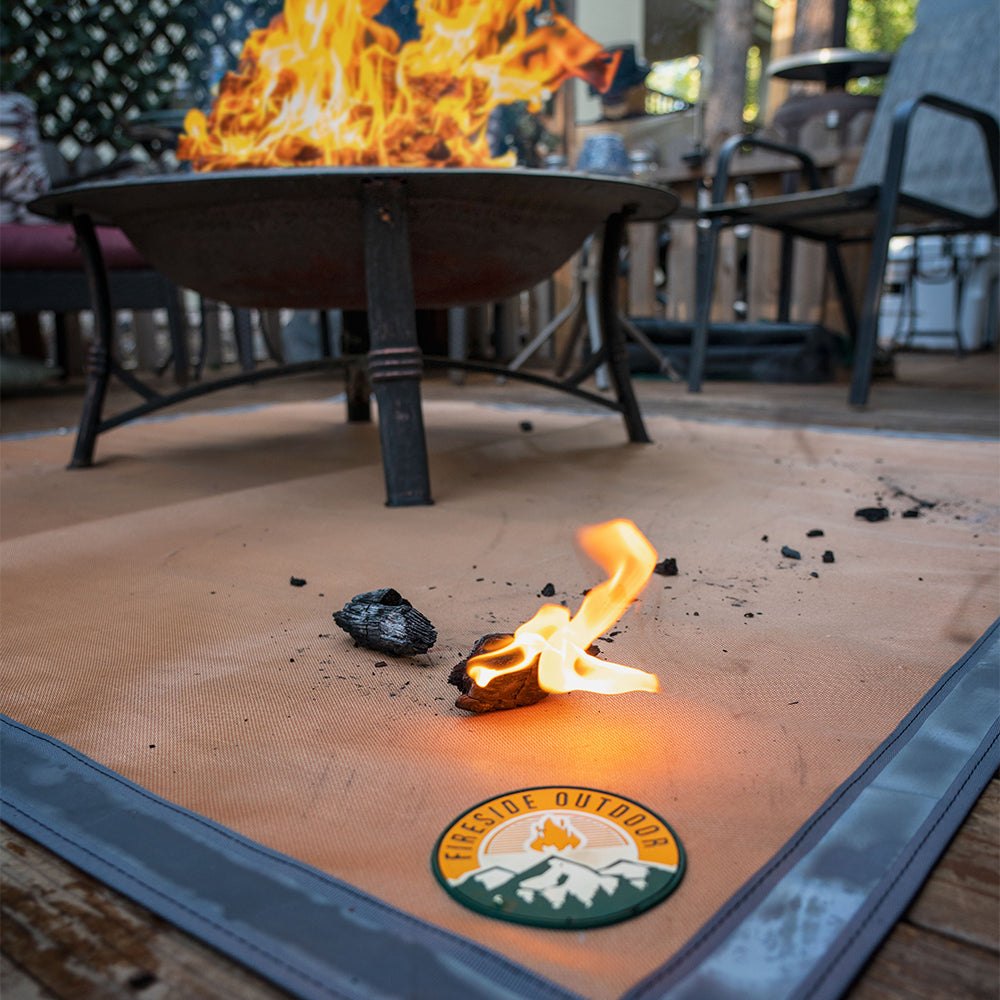 Ground Ember Mat made of fire-resistant thermal weave fiber with silicone coating, featuring high-reflectivity edging and grommets for securing, protecting ground from embers and grease.