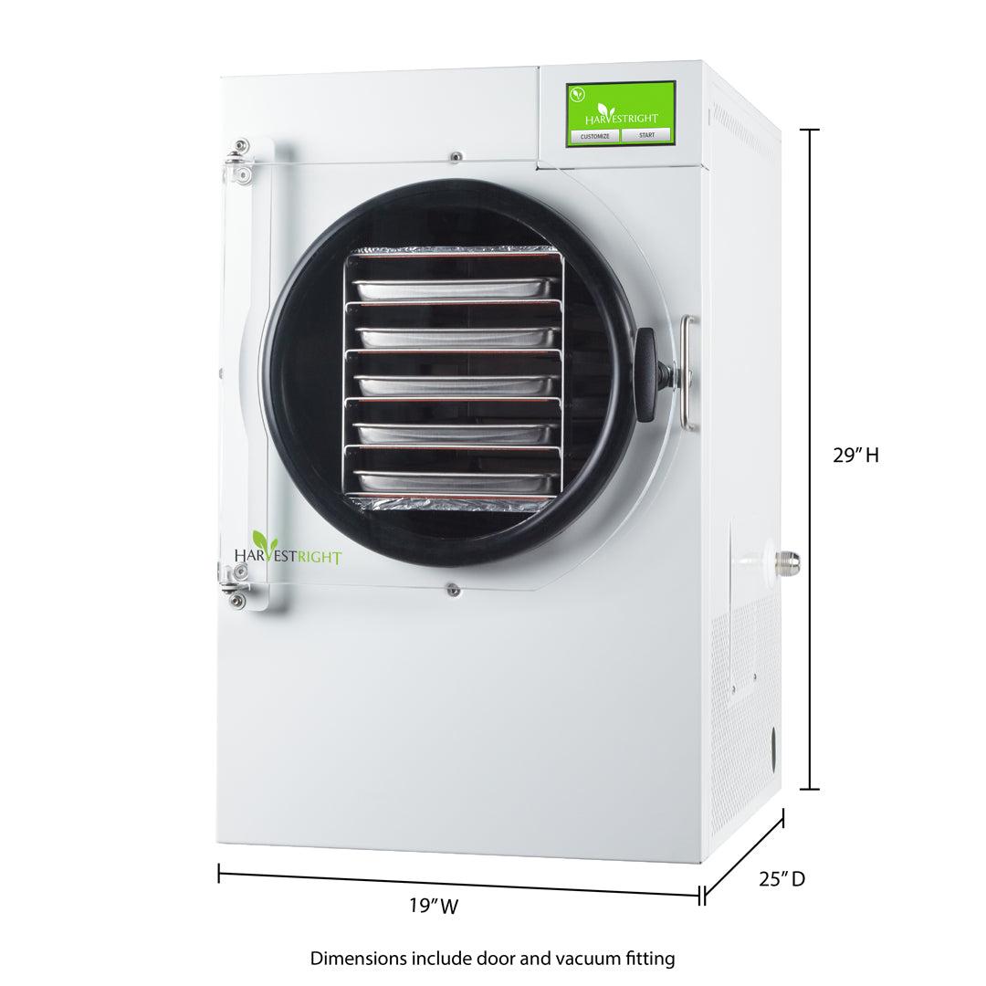 Medium satin white home freeze dryer on countertop with stainless steel trays and vacuum pump accessories