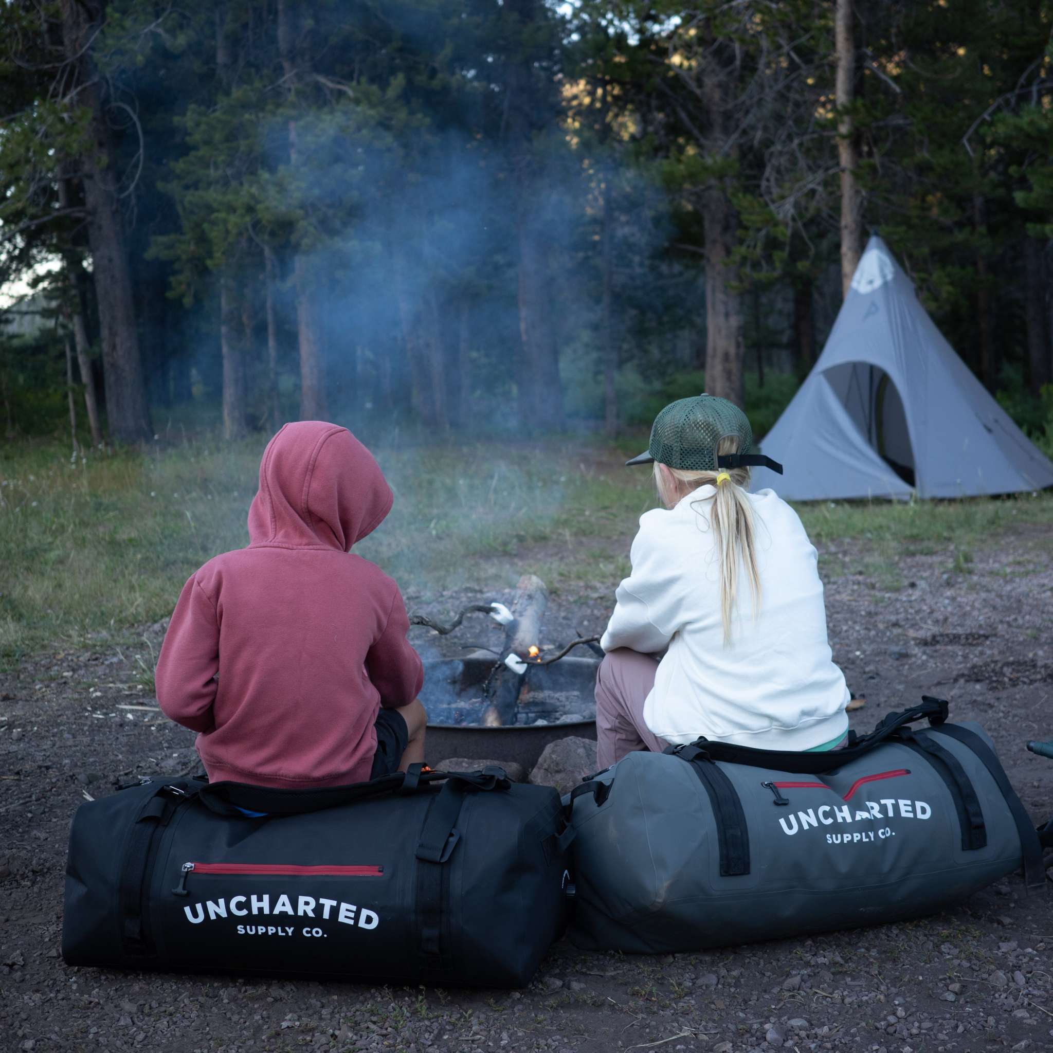 The Vault 65L Duffel Bag in rugged outdoor setting, showcasing waterproof design and ergonomic straps